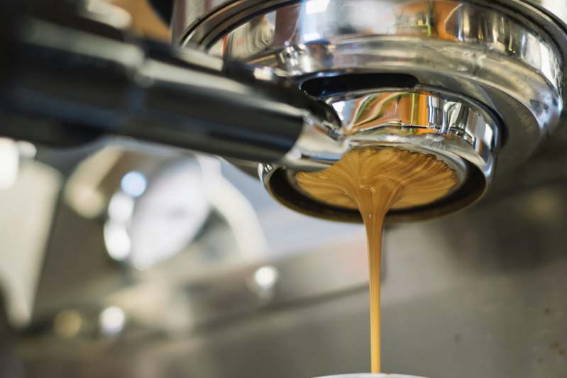 Side profile of a premium smart espresso machine with touchscreen display and sleek brushed stainless steel finish